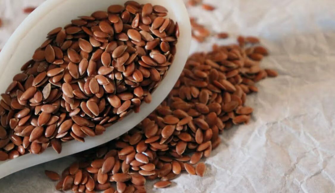 Bowl of brown and golden flaxseeds with a spoon