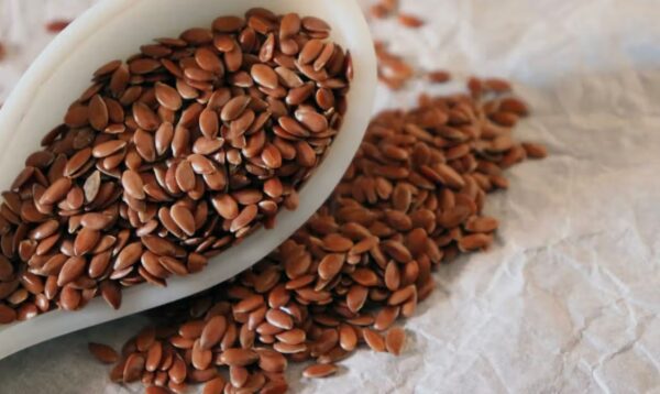 Bowl of brown and golden flaxseeds with a spoon