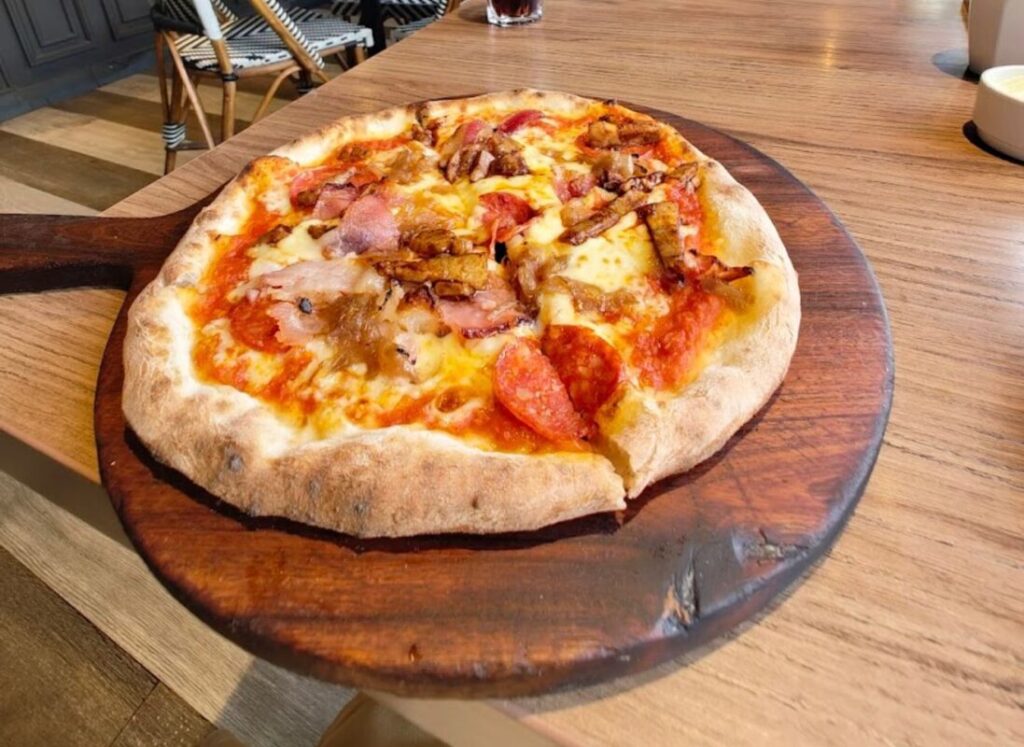 The Pizza Bakery Artisanal Pizza: Celebrating Simplicity & Quality in Every Slice Close-up of The Pizza Bakery's airy, charred pizza crust