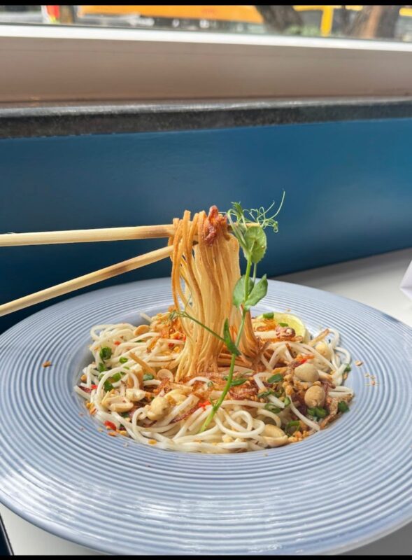 Evo is a Vibe: A Refined Dining Experience in Bangalore Chef preparing a noodle bowl at the open kitchen in Evo Restaurant