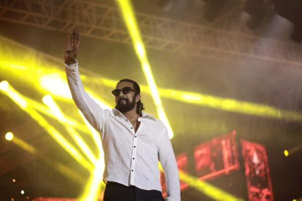 Kiccha Sudeep and Vijayalakshmi Darshan Exchange Sharp Remarks as Fan Rivalry Intensifies Kiccha Sudeep addressing the media at the Mark event, commenting on the ongoing feud.