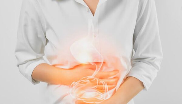 A person hurriedly eating at a desk while working, illustrating the antacid lifestyle.