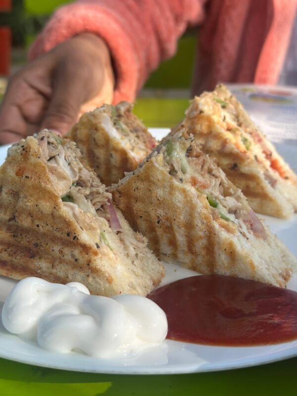 Outdoor seating area of Silver Oak Cafe surrounded by Nandi Hills greenery.