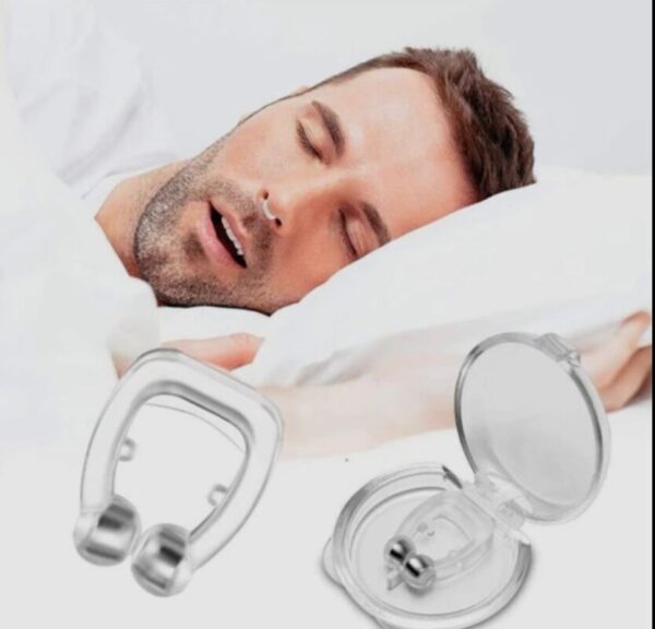 A soft silicone anti-snoring nose clip placed on a person's nostrils.
