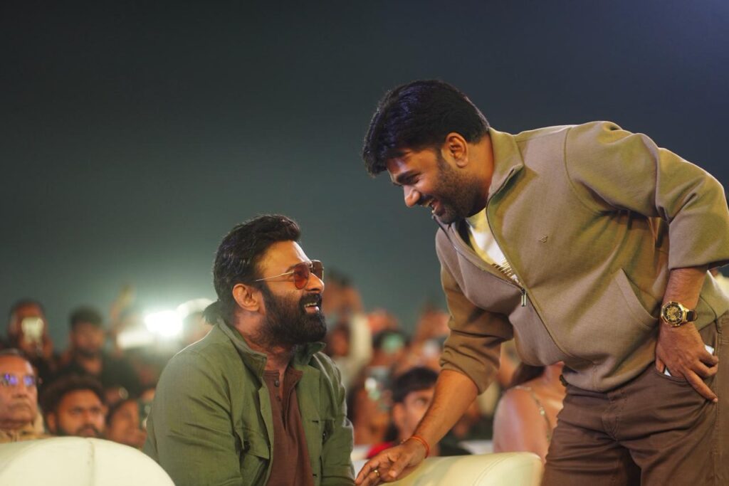 Prabhas Raja Saab Pre-Release Event Sets Stage for Sankranti Spectacle Prabhas and director Maruthi sharing a light moment on stage at The Raja Saab event.
