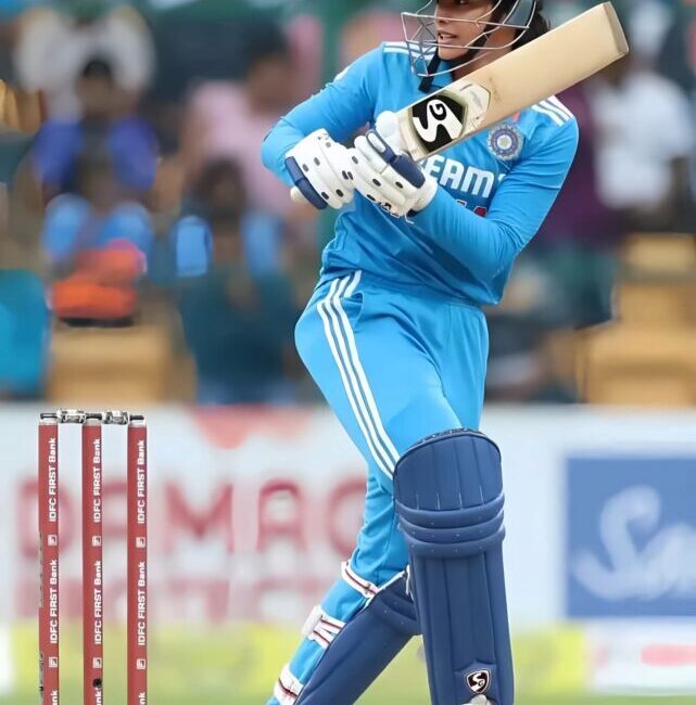 Smriti Mandhana playing a classic cover drive, showcasing her batting elegance.