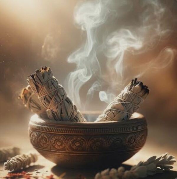 Modern Energy Cleansing Practices for Emotional and Mental Well-being A person performing sage smudging with white sage in a well-lit room.