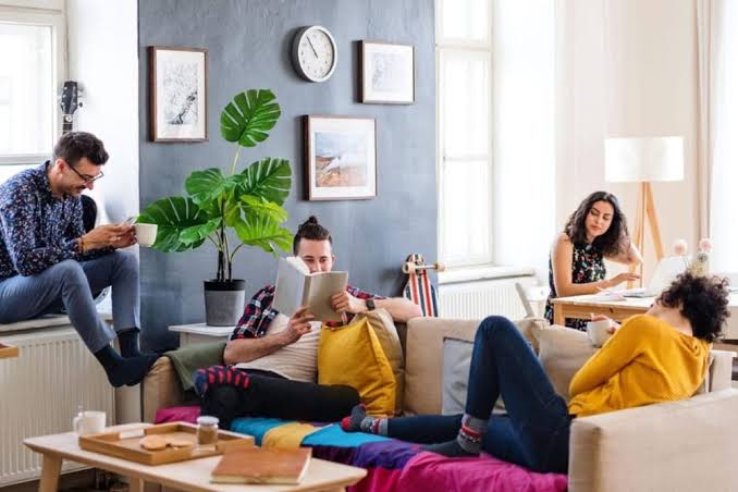 Young professionals collaborating in a shared lounge of a co-working space.
