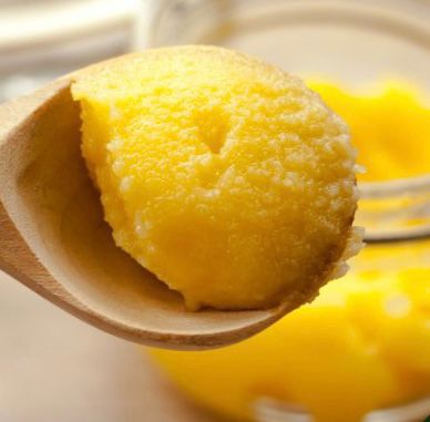 One Tablespoon Ghee Daily Benefits for Holistic Wellness A tablespoon of golden, clarified ghee being drizzled over warm rice or vegetables.